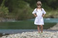 Portrait of cute pretty funny young girl with blond braids in white dress and dark sunglasses Royalty Free Stock Photo