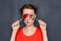 Portrait of cute puzzled girl covering eyes with bright lollipops Royalty Free Stock Photo