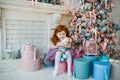 Cute redhead little girl with small teddy bear in hands on Christmas background
