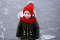 Portrait of cute sad little girl in warm outerwear clothing standing outdoors alone in cool weather Royalty Free Stock Photo