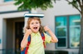 Portrait of cute school boy with glasses and a shirt with holds book. Schoolkid nerd outdoors.