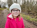 Portrait of a cute school girl with eyeglasses outdoors in park. Happy funny child on autumn, spring or winter day. Royalty Free Stock Photo