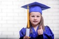 Portrait of cute schoolgirl with graduation hat in classroom Royalty Free Stock Photo