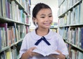 Portrait of cute schoolgirl smiling while reading