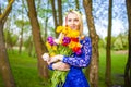 Portrait of Cute and Sensual Romantic Caucasian Blond Girl with Bunch of Tulips Posing Outdoors Royalty Free Stock Photo