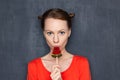 Portrait of cute serious focused young woman eating lollipop Royalty Free Stock Photo