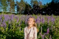 portrait of cute seven year old kid girl with bloom flowers lupines in field of purple flowers. Child throws flowers Royalty Free Stock Photo