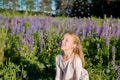 portrait of cute seven year old kid girl with bloom flowers lupines in field of purple flowers. Child throws flowers Royalty Free Stock Photo