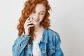 Portrait of cute shy redhead girl smiling looking in side over white background. Copy space. Royalty Free Stock Photo