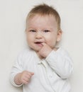 Cute baby laughs and touches his first teeth with his finger Royalty Free Stock Photo
