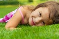 Portrait of cute smiling child girl laying in grass during summer Royalty Free Stock Photo