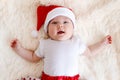 Portrait of a cute smiling five-month-old baby in santa cap. Merry Christmas. children for the new year