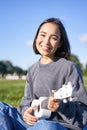 Portrait of cute smiling girl playing ukulele in park. Young woman with musical instrument sitting outdoors Royalty Free Stock Photo