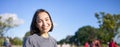 Portrait of cute smiling girl playing ukulele in park. Young woman with musical instrument sitting outdoors Royalty Free Stock Photo