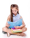Portrait of cute smiling happy little school girl child teenager sitting on a floor and reading the book isolated