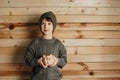 Portrait of cute smiling little boy with piggy bank on wooden background. Child with money in green hat. Royalty Free Stock Photo