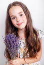 Portrait of cute smiling little girl with bunch of lavender flowers