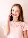 Portrait of cute smiling little girl calling by cell phone smar