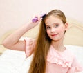 Portrait of cute smiling little girl child brushing her hair Royalty Free Stock Photo