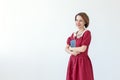 Portrait of cute smiling modest woman in dress holding classic book in hands on white background. Concept of lovers of