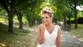 Portrait of cute smiling newly married bride walking at park and looking in camera