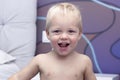 Portrait of cute smiling toddler with chickenpox. Funny baby boy with varicella