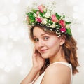 Portrait of a cute smiling young girl in a wreath of roses