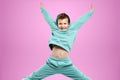 Portrait, cute stylish boy in a blue suit on a pink background. Studio portrait of a child, modern design, trendy background,