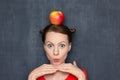 Portrait of cute surprised girl with red apple on head Royalty Free Stock Photo