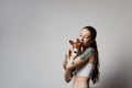 Portrait of a cute tattooed young woman hugging and kissing her little puppy basenji dog. Love between dog and owner Royalty Free Stock Photo