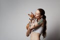 Portrait of a cute tattooed young woman hugging and kissing her little puppy basenji dog. Love between dog and owner Royalty Free Stock Photo