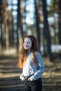 Cute teen girl with fiery red hair in the pine park Royalty Free Stock Photo