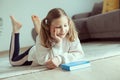 Portrait of cute teen girl reading book on floor in room at home Royalty Free Stock Photo