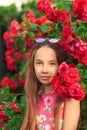 Portrait of cute teen girl smiling at the roses Royalty Free Stock Photo