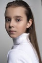 Portrait of a cute teen girl wearing a white turtleneck sweater. Isolated on gray background. Advertising, trendy and commercial