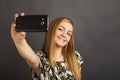 Portrait of cute teenage girl taking selfie with her smart phone Royalty Free Stock Photo