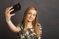 Portrait of cute teenage girl taking selfie with her smart phone Royalty Free Stock Photo