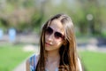 Portrait of a cute teenage girl wearing sunglasses in a park on a sunny summer day. Close-up. Concept. Horizontal Royalty Free Stock Photo