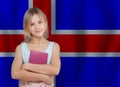 Portrait of cute teenager girl holding book on flag of Iceland background