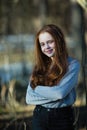 Cute teengirl with long bright red hair in the Park