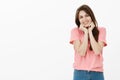 Portrait of cute and tender girlfriend in pink t-shirt, holding palms on jaw and smiling broadly being touched with