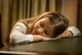 Portrait of cute tired schoolgirl sleeping on desk