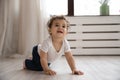 Portrait cute toddler African American girl crawling on wooden floor Royalty Free Stock Photo