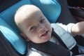 Portrait of cute toddler boy sitting in car seat. Child transportation safety