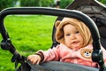 Portrait of a cute toddler girl in a stroller in the park Royalty Free Stock Photo