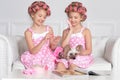 Portrait of cute tweenie girls with hair curlers sitting