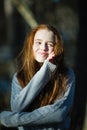 Portrait of twelve year old girl with fiery red hair posing in the pine park for a photoshoot Royalty Free Stock Photo