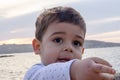 Portrait of cute two years old boy on the beach pointing finger to something close up Royalty Free Stock Photo