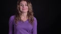 Portrait of cute woman gesturing finger-up signs gladly into camera to show like and respect on black background.