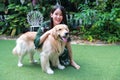 Portrait of cute woman playing with dog on green grass Royalty Free Stock Photo